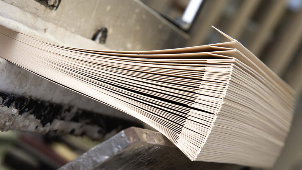 Stack of neatly aligned cardboard sheets ready for packaging.