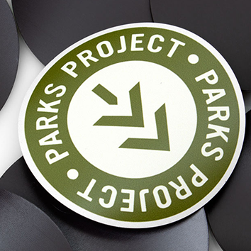 Green circular sticker with 'Parks Project' text and arrow logo.