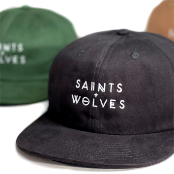 Two casual caps with 'SAINTS WOLVES' text, one black and one green.